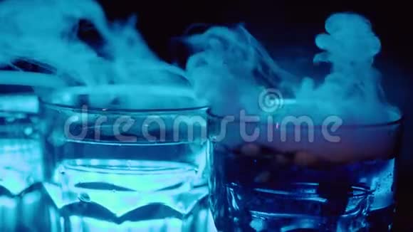 在夜总会里从酒吧里的干冰中取出弹簧圈慢动作眼镜和蒸汽视频的预览图