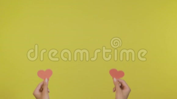女博主手捧小红心随着音乐节奏舞动隔离在黄橙色背景上就像视频的预览图