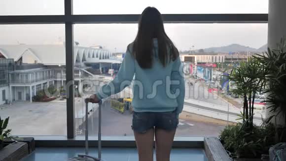 小女孩正在机场窗口附近等待她的航班行李是4k视频的预览图