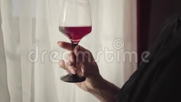 特写优雅的女性白种人手拿酒杯与红酒带酒杯的时尚美甲女士视频的预览图