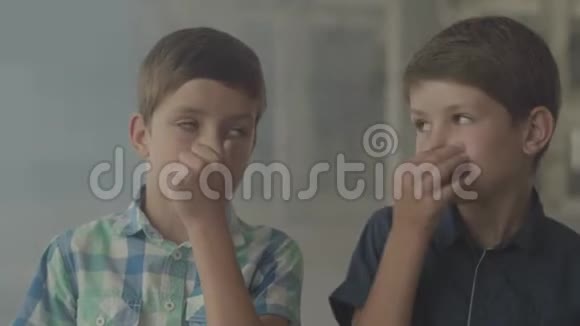两个困惑的男孩站在烟雾弥漫的房间里用手闭上鼻子危险的概念火灾视频的预览图