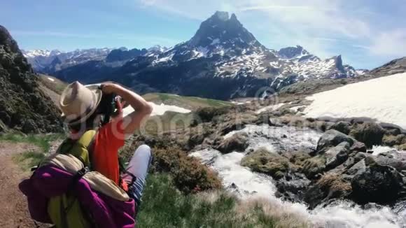 女徒步旅行者在法国比利牛斯山脉的PicduMididOssau拍照视频的预览图