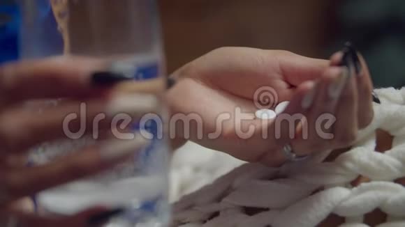 女性在床上拿着药和一杯水视频的预览图
