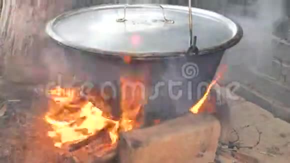 用黑色搪瓷锅或炊具烹饪动作用于户外明火烹饪准备古拉什视频的预览图