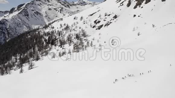 冬天的空中飞人带着雪鞋在雪坡上徒步旅行冬季仙境全景视频的预览图