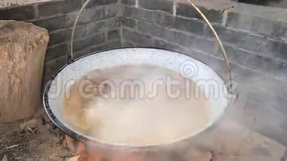 在一个深油炸锅里加入肉和骨头的热泡开水视频的预览图