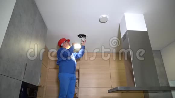 电工丈夫将LED灯安装到天花板上工人微笑竖起大拇指视频的预览图