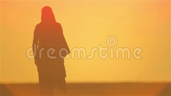 一个孤独地站在沙漠中的阿拉伯女人的剪影视频的预览图