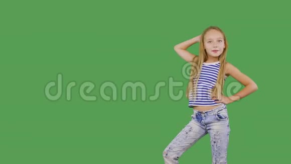 年轻女孩模特在绿色背景上摆着前摄像头少女微笑着看着镜头拍照视频的预览图