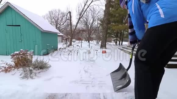 女人在寒冷中挣扎着铲雪有困难慢动作视频的预览图