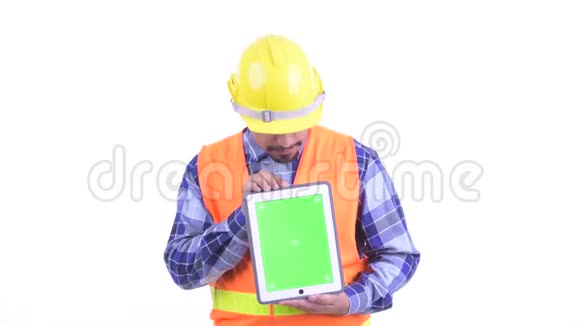 幸福的长胡子的波斯建筑工人一边思考一边展示数字平板电脑视频的预览图