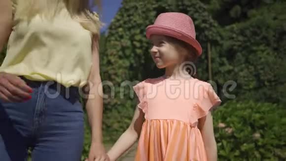 妈妈和小可爱女儿一起走在夏园牵着手家庭幸福女人和女孩在一起视频的预览图