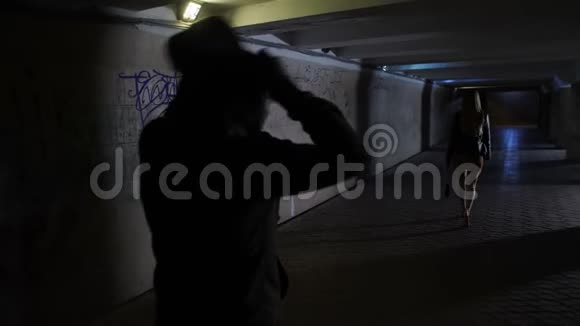 穿着帽衫的男人在黑暗隧道里追女人视频的预览图