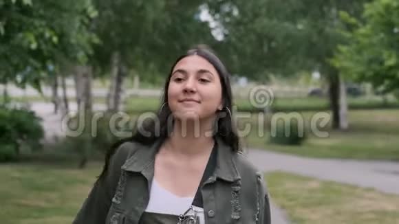 快乐的时髦女孩在公园里随着音乐跳舞手里拿着一个便携式扬声器特写视频的预览图