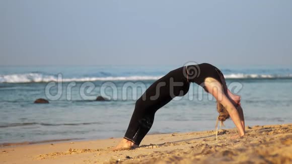 金发女孩在海滩上展示高级瑜伽姿势轮视频的预览图