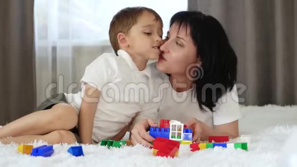 母子关系的概念快乐的宝宝和妈妈躺在沙发上玩麦可诺一位母亲视频的预览图