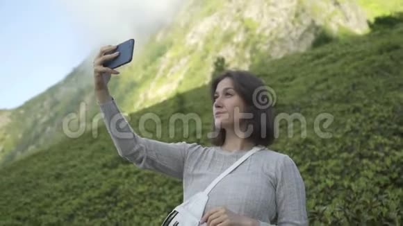 美丽的黑发女孩在山上背景下自拍视频的预览图