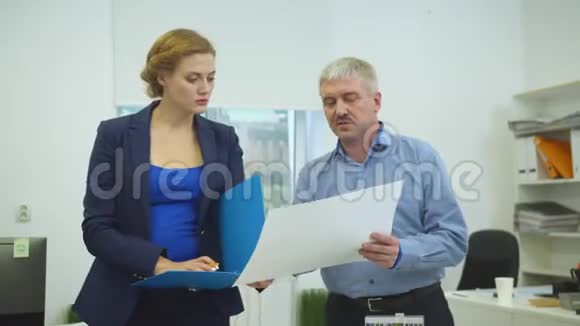 男人拿着文件给女人看文件视频的预览图