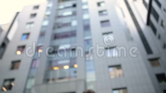 一个男人在高楼前用平板电脑视频的预览图