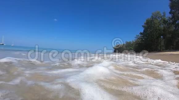 从海浪中冒出很多泡沫有新的大浪潮热带岛屿度假胜地的沙滩视频的预览图