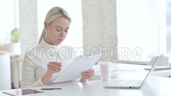 成功的女商人在办公室阅读文件视频的预览图