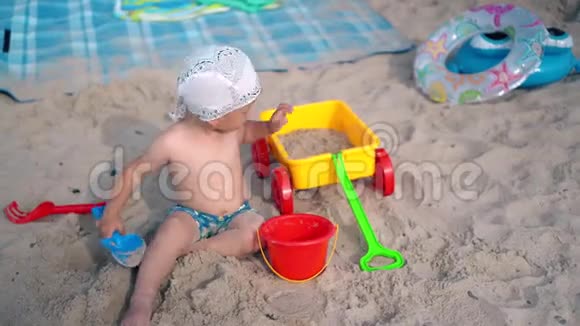 幼儿在沙滩上玩沙子和玩具家庭假日概念视频的预览图