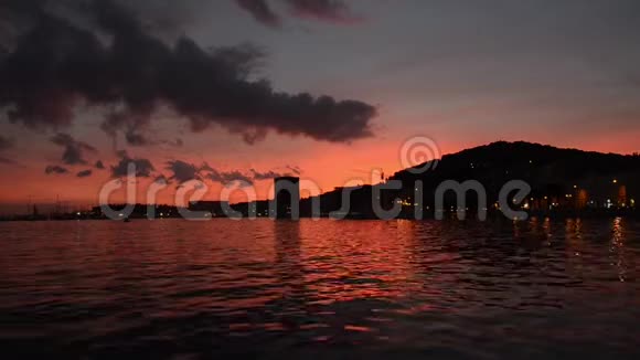 美丽的红色日落在海上和戏剧性的天空水中的光反射夏天港口的橙色天空斯普利特晚上视频的预览图