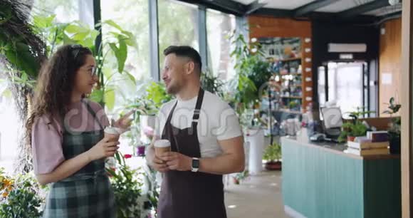 工作间休息时鲜花店的工作人员微笑着端着咖啡视频的预览图