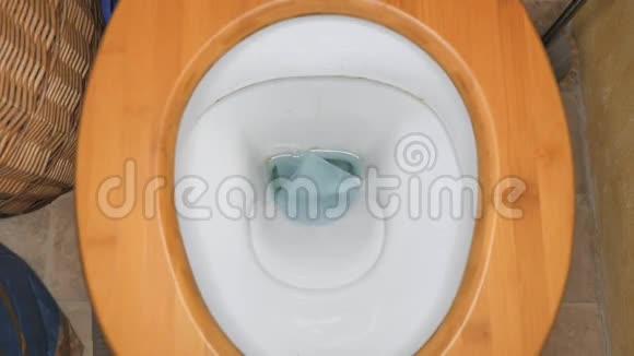 平面休息室白色马桶一个冲洗式白色厕所的特写俯视图蓝色的水在碗里旋转视频的预览图