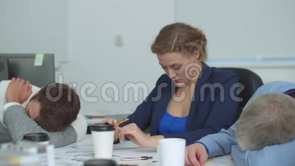 疲倦的女人坐在桌子上睡着了视频的预览图