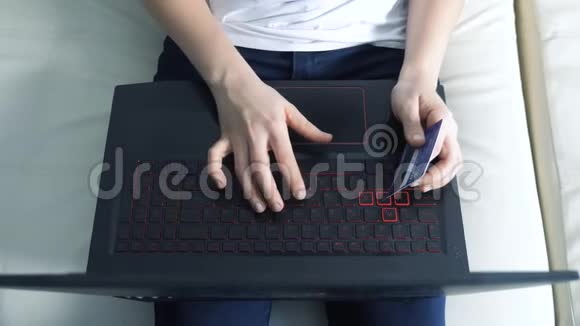 女孩制作网上销售购物概念与笔记本电脑数字平板生活方式黑发女人躺在沙发上看着商店视频的预览图