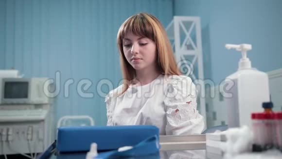 男医生戴一次性手套女病人坐在那里等待化验视频的预览图