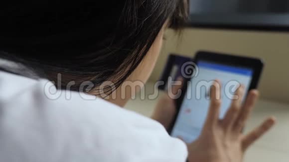 女孩用生活方式数字平板电脑制作网上购物概念黑发女人躺在沙发上看网上商店视频的预览图