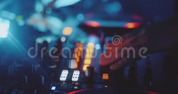 男子DJ在夜总会的混合控制台上演奏音乐视频的预览图