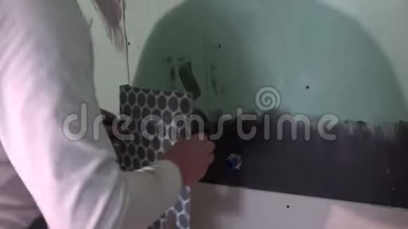 拖车人在浴室的冷热水管周围涂上墙砖视频的预览图