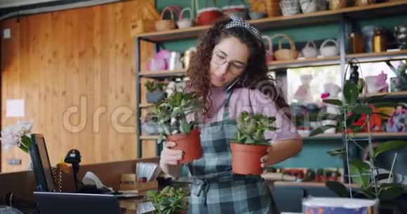 花店里可爱的女售货员在手机上说植物视频的预览图