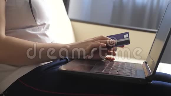 女孩用笔记本电脑数字平板电脑制作网上销售购物概念黑发女人躺在沙发上看着商店视频的预览图