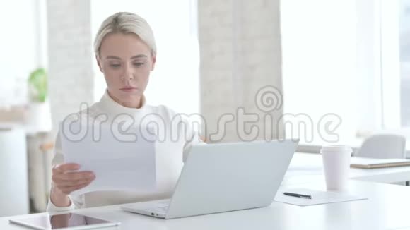 雄心勃勃的年轻女商人在笔记本电脑上使用文件视频的预览图