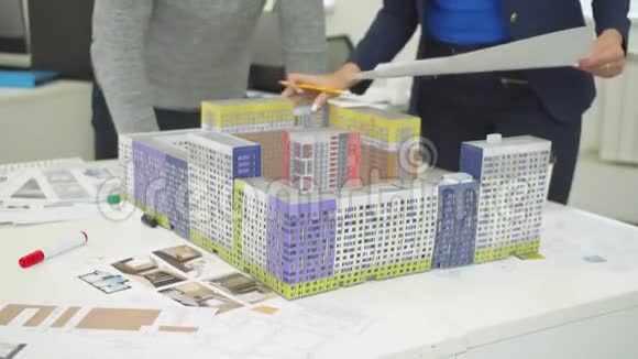 有计划的工程师展示房屋模型并向同事解释一些事情视频的预览图