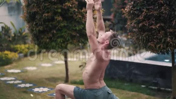 无衫男子肌肉男在花园里做瑜伽运动的肖像视频的预览图