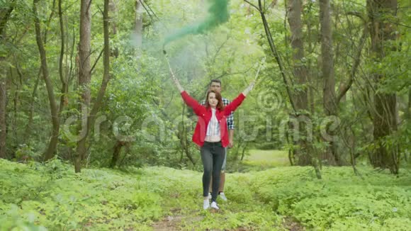 年轻女子在森林里用吸烟的火炬跳舞视频的预览图