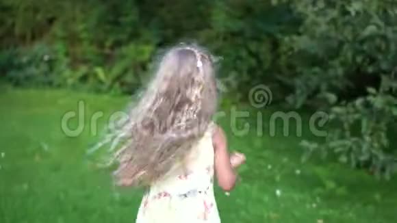快乐的小女孩跑在花园里躲在树间视频的预览图