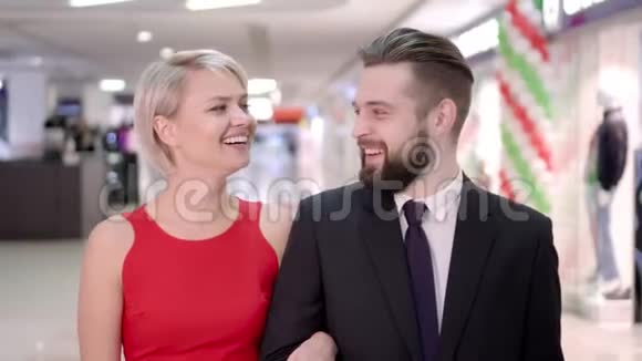 出售消费主义和人的概念幸福的年轻夫妇带着购物袋走在商场里视频的预览图