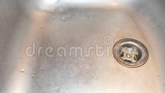 厨房不锈钢水槽中的水喷到金属排水沟上水龙头里的水充满了水槽视频的预览图