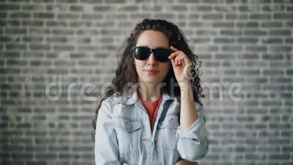 一幅美丽的时髦女孩戴着太阳镜凝视着惊讶的肖像视频的预览图