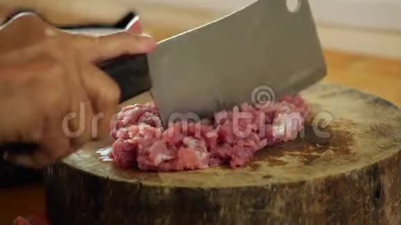 自制食物慢吞吞地在木切割板上切生猪肉视频的预览图