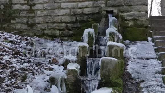 在冬天的一天一股泉水沿着古老的石渠流下来视频的预览图