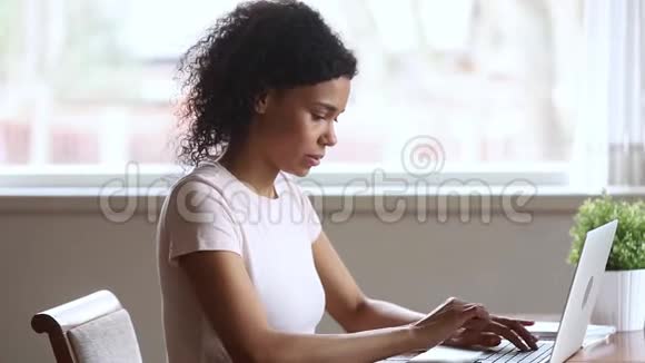 喜出望外的非洲女学生感到胜利者看着笔记本电脑视频的预览图