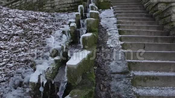 在冬天的一天一股泉水沿着古老的石渠流下来视频的预览图