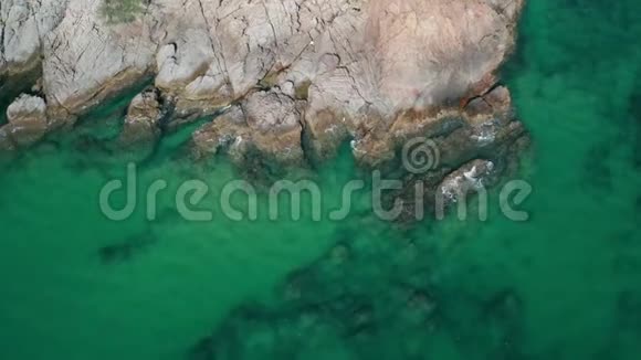 绿松石海表面的空中俯视水中有石头和岩石视频的预览图